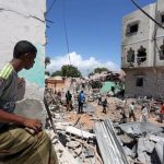 A Somali man watches the damage caused at the scene where a car exploded in the Madina district of Mogadishu